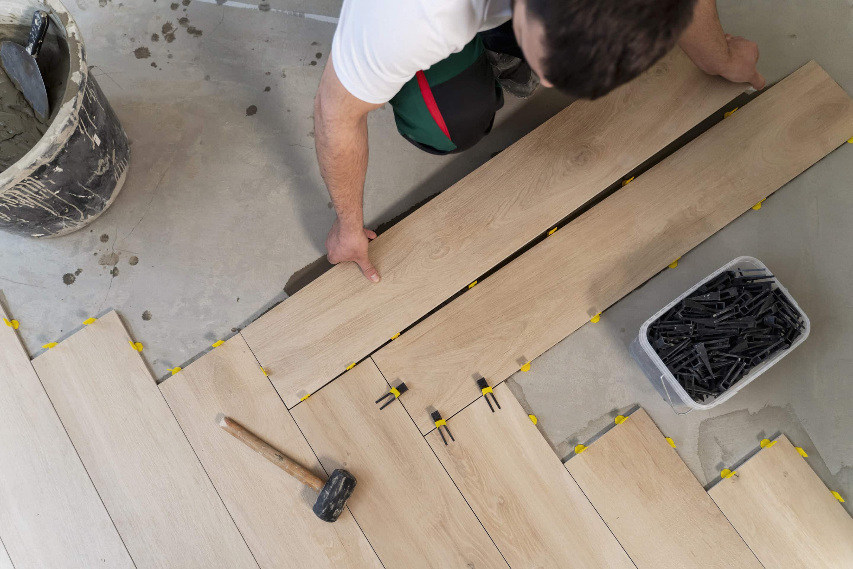 flooring adhesives being used to lay down wooden planks